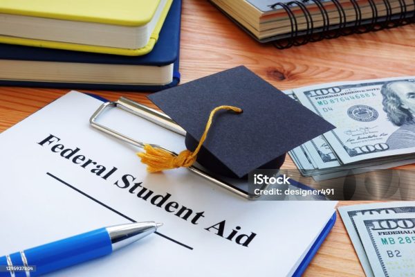 Federal student aid papers and small Square academic cap.